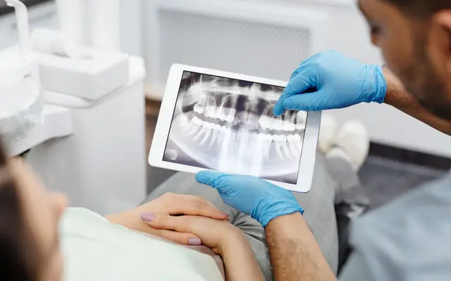 Dentist showing a patient their dental X-ray on a tablet