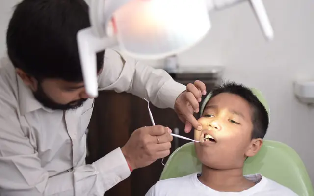 Dentist checking a young boy’s teeth